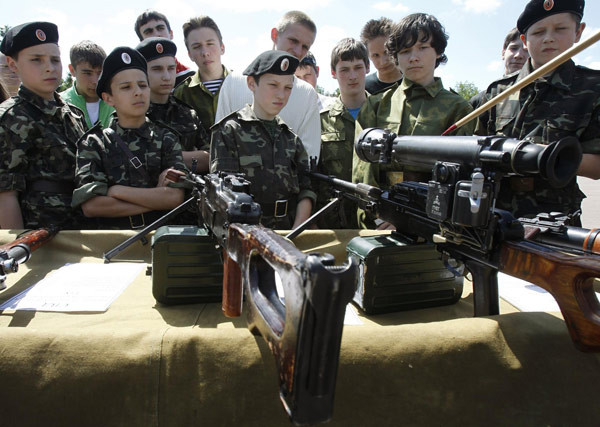Ukrainian teenagers look at weapons at a military base in the town of Zhytomyr, some 135 km (84 miles) west of Kiev, May 26, 2011. As part of a campaign to promote patriotic upbringing, Ukrainian NGO 