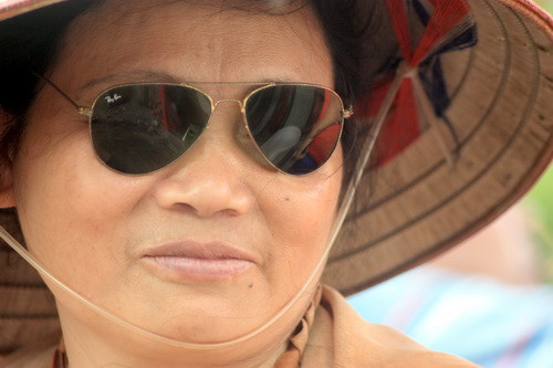 Dưới cái nắng oi bức, người phụ nữ này đeo kính mát để dịu mắt. Ảnh, gdtd.vn