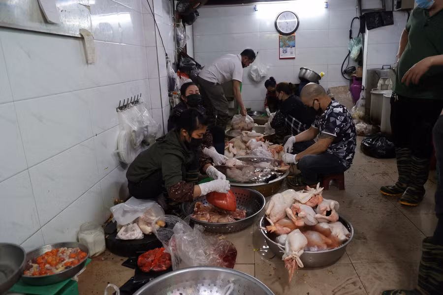 Phía bên trong, nhiều nhân viên tại cửa hàng tất bật để làm gà chuẩn bị cho khách hàng.