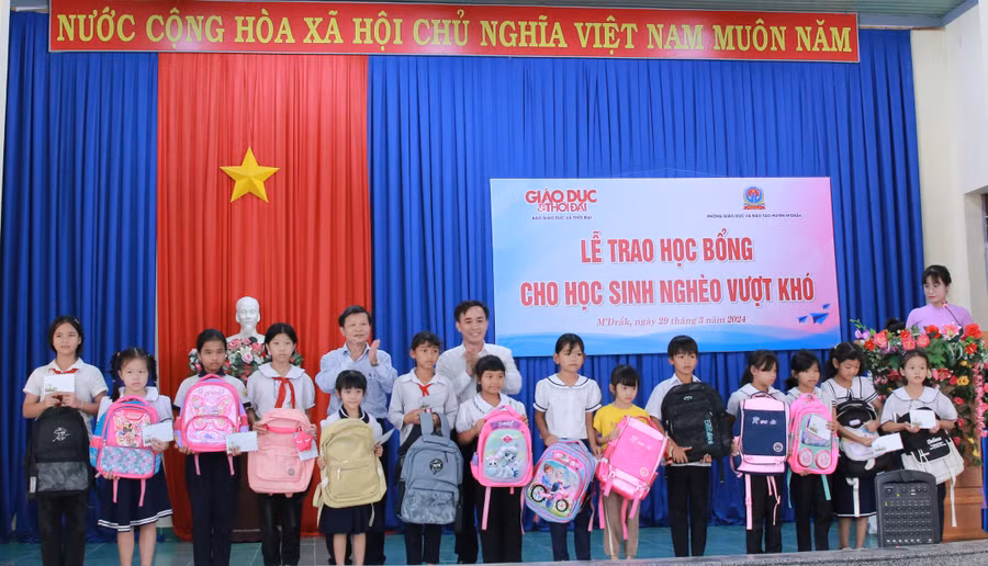 Ban tổ chức trao học bổng, cặp sách cho học sinh. (Ảnh: TT)