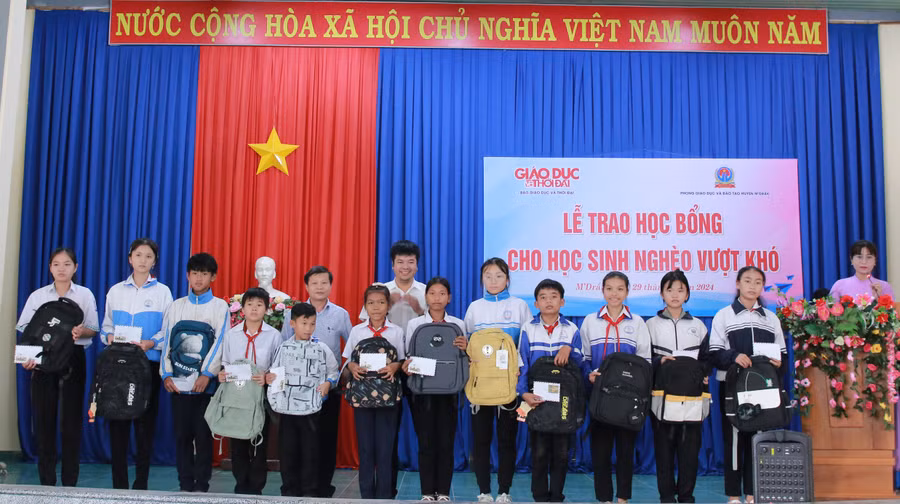 Ban tổ chức trao học bổng, cặp sách cho học sinh. (Ảnh: TT)