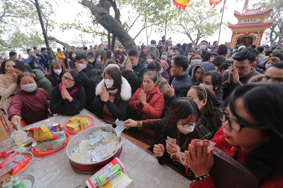 Ban thờ trong và ngoài sân phủ kín tiền lẻ của người đi lễ để lại.