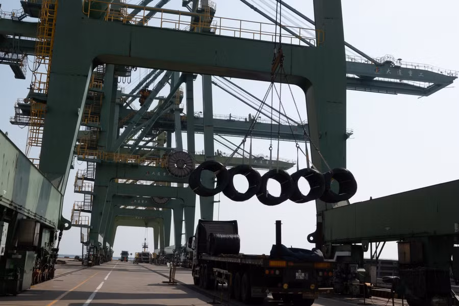 Thép được bọc cáp và cẩu lên tàu hàng chờ sẵn tại bến.