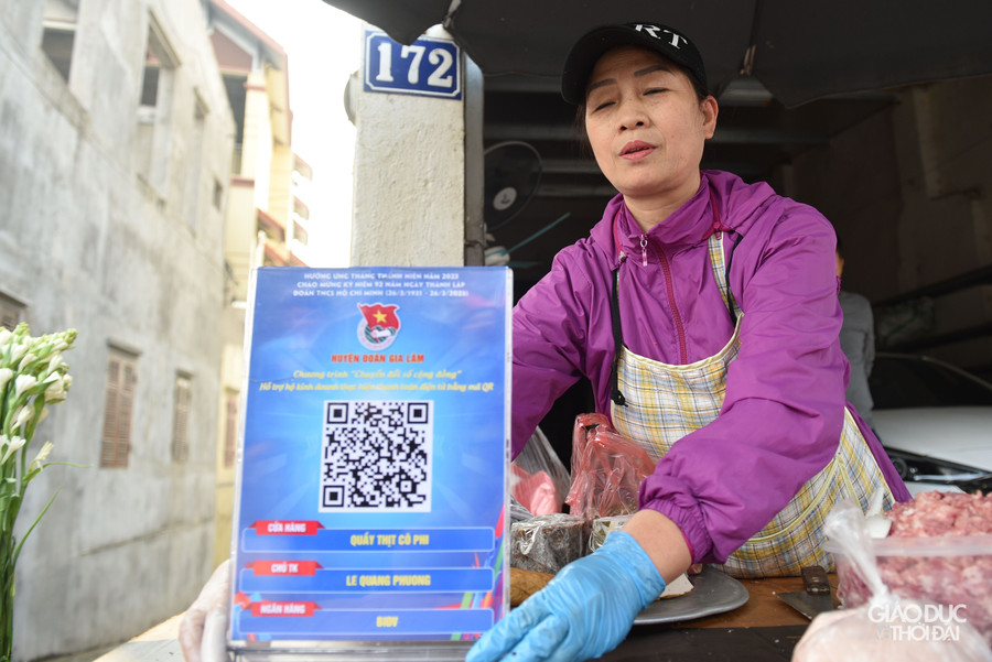 Tình nguyện viên hỗ trợ người dân triển khai chuyển đổi số Mã QR code tại các hộ kinh doanh xã Phù Đổng, huyện Gia Lâm.