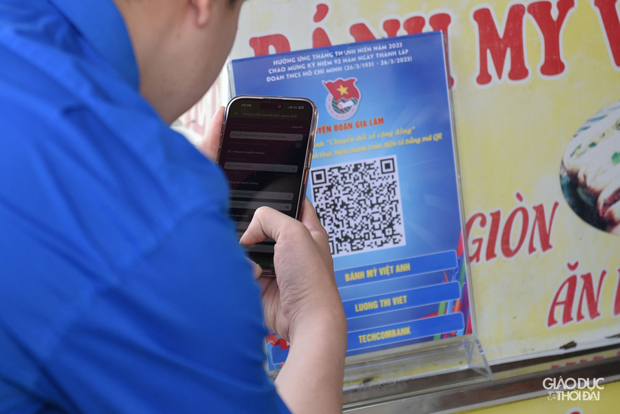 Tình nguyện viên hỗ trợ người dân triển khai chuyển đổi số Mã QR code tại các hộ kinh doanh xã Phù Đổng, huyện Gia Lâm.