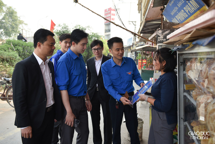 Tình nguyện viên hỗ trợ người dân triển khai chuyển đổi số Mã QR code tại các hộ kinh doanh xã Phù Đổng, huyện Gia Lâm.