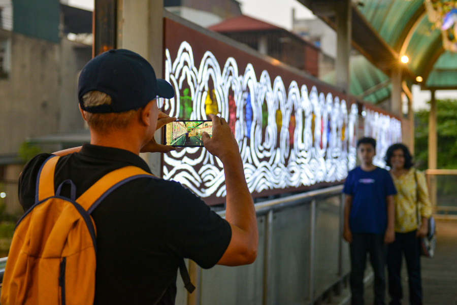 Xen giữa những lớp sóng là hình ảnh tái hiện những người lao động trong nghiên cứu về “Kỹ thuật của người An Nam” của họa sĩ Henri Oger.