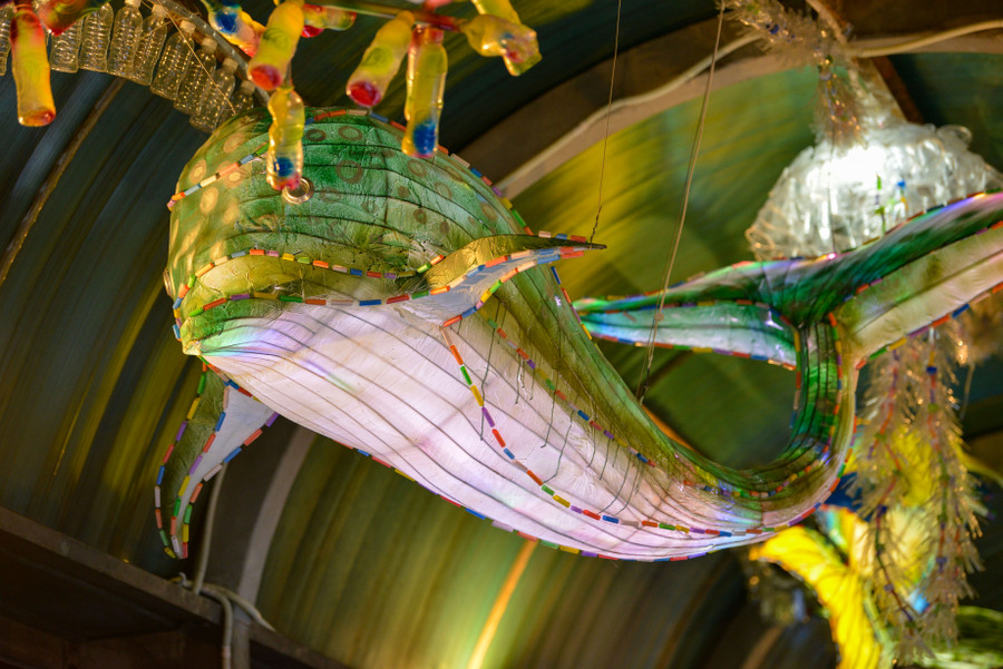 Tác phẩm “Thủy cung” của nhóm nghệ sĩ đã biến cây cầu đi bộ thành tác phẩm sắp đặt ánh sáng, giống như 1 đường &quot;hầm thủy cung&quot; đầy hấp dẫn với đủ loài cá đại dương đang bơi lội phía trên vòm cầu. Các loài cá, mực, sứa… được làm từ vỏ chai nhựa, cốc nhựa, ống hút nhựa, nilon tái chế….