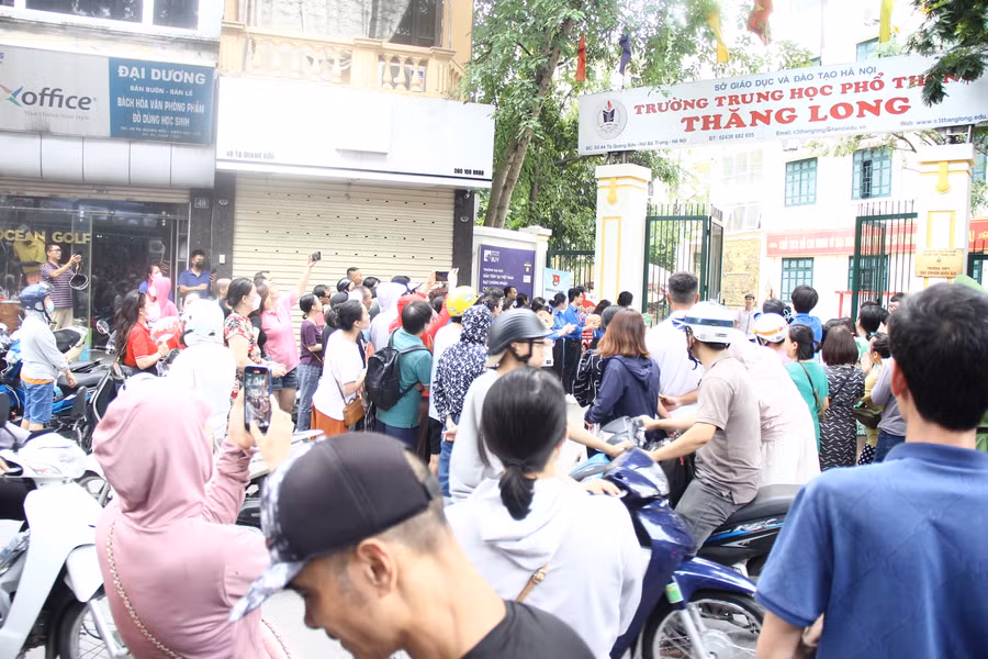 Ngóng trông con từ bên ngoài cổng trường