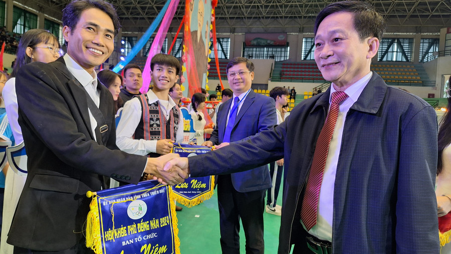 Ban tổ chức tặng cờ lưu niệm cho các đoàn dự thi.