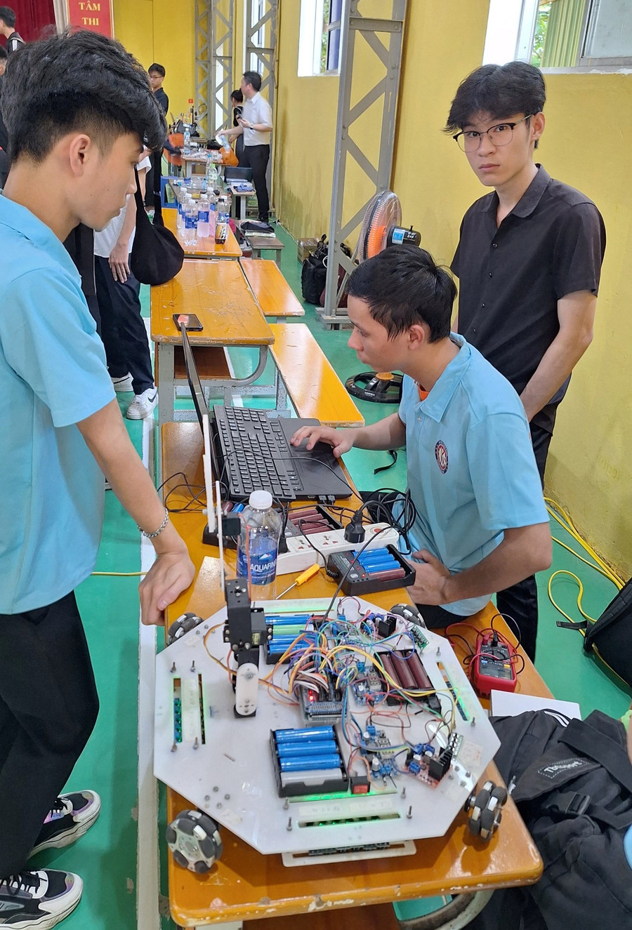 Thành viên các đội kiểm tra lại phần lập trình trên máy nối với Robot trước khi thi đấu.