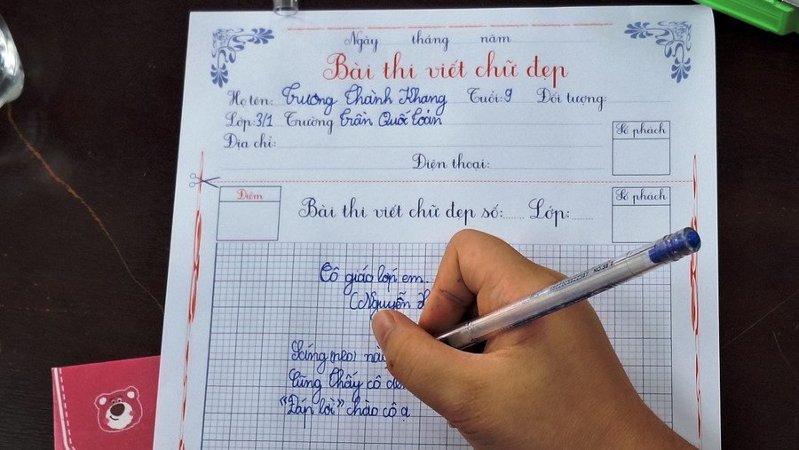 Các học sinh dồn sức để viết chữ đẹp.
