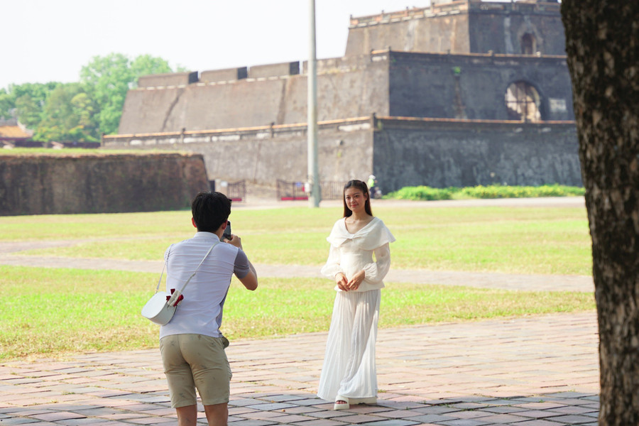 Chụp ảnh cho bạn gái trong khung cảnh cổ kính mát mẻ tại Hoàng thành Huế. (Ảnh: L.N).