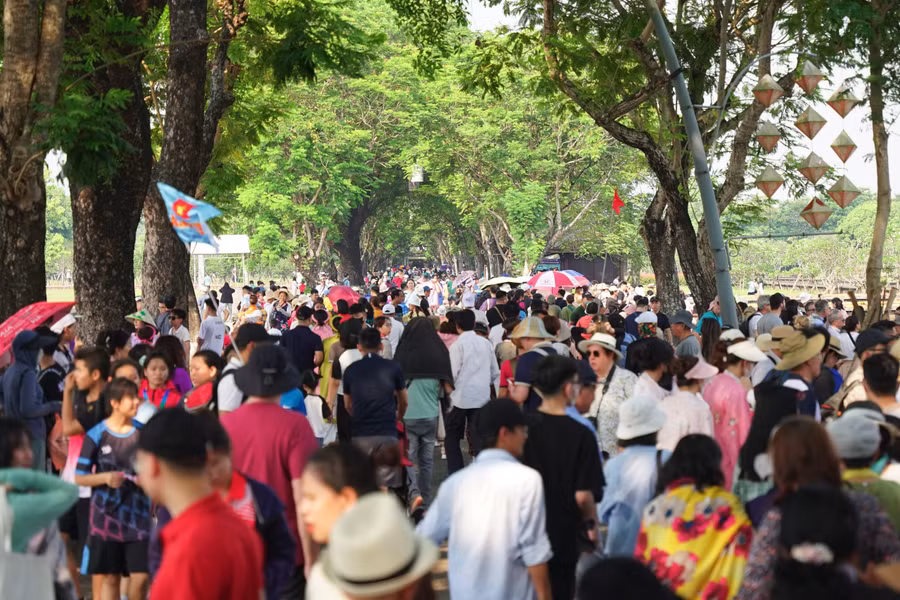Rất đông du khách đến tham quan Hoàng thành Huế dưới con đường phủ đầy bóng cây xanh. (Ảnh: L.N).