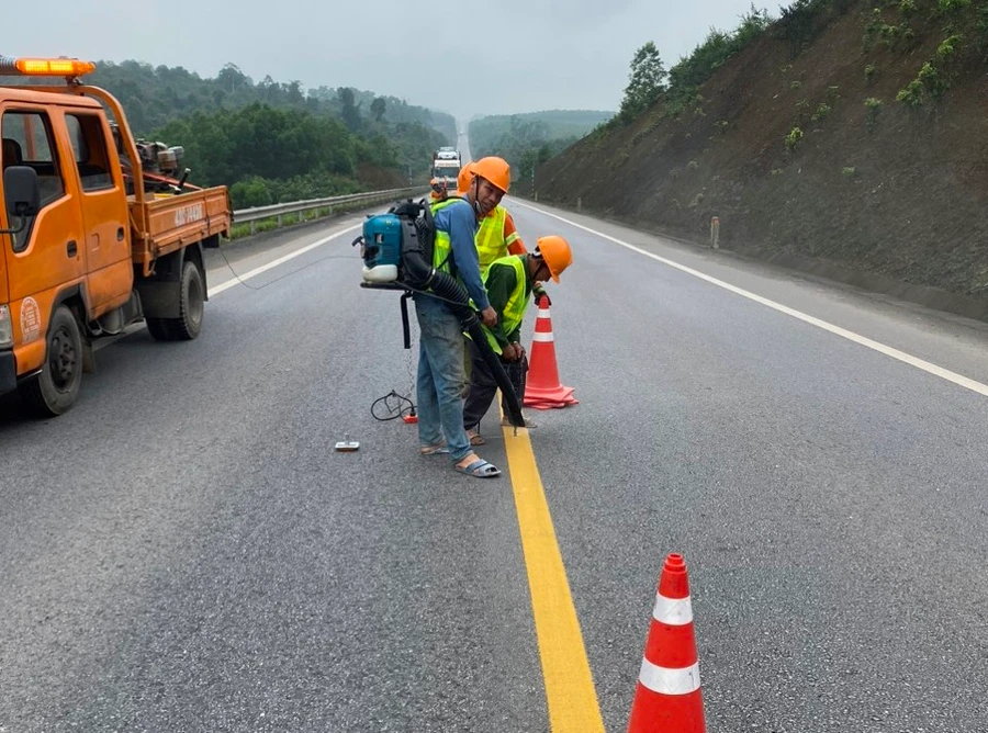 Công nhân đang sơn kẻ vạch và các việc khác trong gói hệ thống an toàn được bổ sung cho cao tốc Cam Lộ - La Sơn. (Ảnh: N.V)