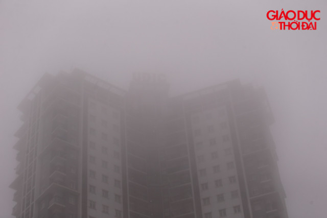 Những toà nhà cao tầng chỉ có thể nhìn được những tầng ở thấp, những tầng trên cao chìm hẳn trong lớp sương dày đặc. Những toà nhà cao tầng chỉ có thể nhìn được những tầng ở thấp, những tầng trên cao chìm hẳn trong lớp sương dày đặc.