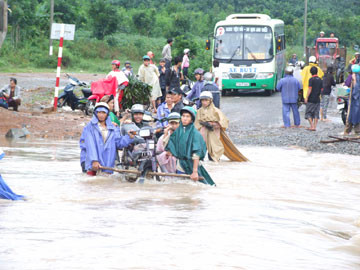 Tràn Bà Sao trên ĐT645 ngập nặng, người dân phải thuê khiêng xe qua với giá cao - Ảnh: N.CƯỜNG