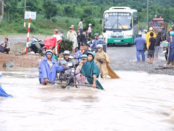 Tràn Bà Sao trên ĐT645 ngập nặng, người dân phải thuê khiêng xe qua với giá cao - Ảnh: N.CƯỜNG