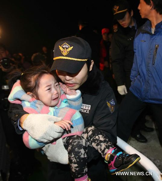 A police officer carries a terrified child on the Yeonpyeong Island hit by artillery shells the Democratic People’s Republic of Korea (DPRK) 