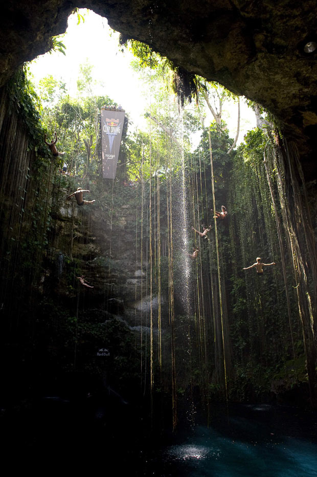 Kinh hoàng những hố địa ngục trên thế giới ảnh 12 Cliff divers leap into the cenote or sinkhole during training in the lead up round two of the 2010 Red Bull Cliff Diving world series at the Cenote Ik Kil, near Chichen Itza in the Yucatan peninsula, Mexico. Cenotes are usually formed by collapsing cave systems. The Zacaton cenote in the Yucatan peninsula is the largest water-filled sinkhole in the world with a total depth of 335 metres