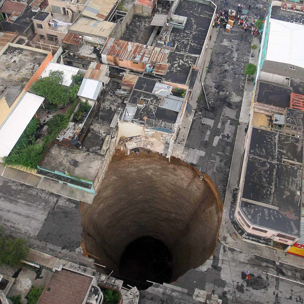 Kinh hoàng những hố địa ngục trên thế giới ảnh 2 A huge, almost perfectly circular sinkhole, 100 feet (30 metres) and 200 feet (60 metres) deep, opened up suddenly May 30 in Guatemala City, after Tropical Storm Agatha...