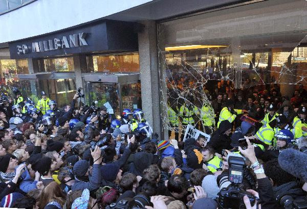 Police and demonstrators confront each other in the foyer of the Conservative Party headquarters building during a protest in central London November 10, 2010. Students demonstrating against higher tuition fees burned placards, scuffled with riot police and smashed windows at the headquarters of Britain’s governing Conservative party on Wednesday. (Xinhua/Reuters Photo)