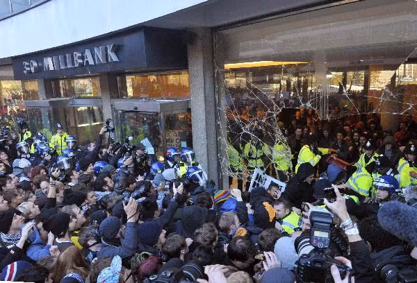 Police and demonstrators confront each other in the foyer of the Conservative Party headquarters building during a protest in central London November 10, 2010. Students demonstrating against higher tuition fees burned placards, scuffled with riot police and smashed windows at the headquarters of Britain’s governing Conservative party on Wednesday. (Xinhua/Reuters Photo)