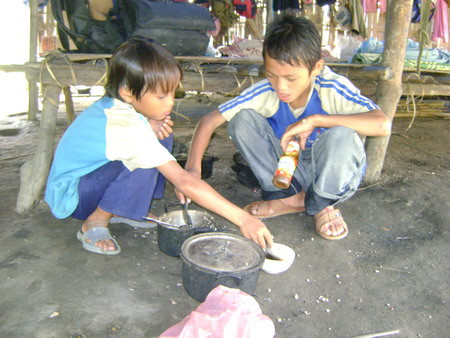 Anh em Trần Văn Dương bên nồi cơm nguội và chén nước mắm nem Anh em Trần Văn Dương bên nồi cơm nguội và chén nước mắm nem ăn qua ngày.