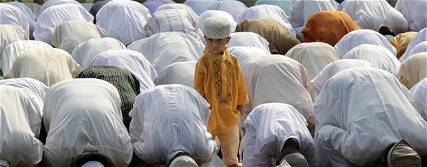 A child stands amid bowing adults at a mosque in Calcutta, India