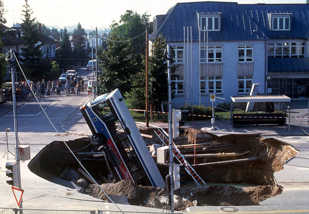 Kinh hoàng những hố địa ngục trên thế giới ảnh 20 A bus lies in a crater caused by construction work in a road in Munich, 1994