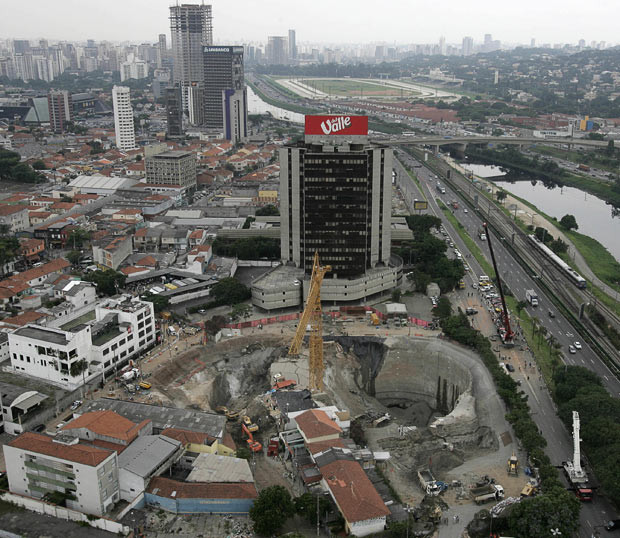 Kinh hoàng những hố địa ngục trên thế giới ảnh 14 A huge crater at the collapsed Pinheiros subway station in Sao Paulo, Brazil, in January 2007. The giant sinkhole that opened at a construction site in South America’s biggest city. A passenger minivan fell to the bottom of a 40-metre (130-foot) deep pit dug to facilitate delivery of supplies for workers building an underground railway line. The lip of the hole gave way to a landslide, taking with it vehicles on a roadway around the edge and dumping tons of earth, asphalt and concrete atop them