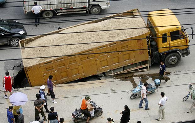 Kinh hoàng những hố địa ngục trên thế giới ảnh 11 In June 2009, a lorry carrying a load of sand fell into a hole that opened up in a road in Wuhan, Hubei Province, China
