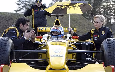 Russia’s Prime Minister Vladimir Putin listens to instructions from Renault Formula One team members before test driving the car at a racing track in Leningrad