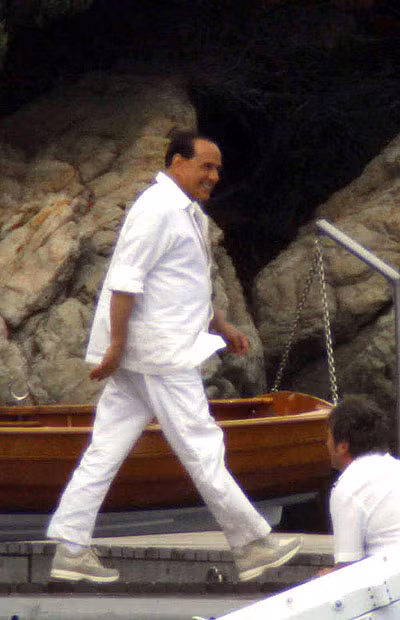 Grinning like a Cheshire cat, Silvio Berlusconi prepares to board the yacht of Formula One mogul Flavio Briatore in Sardinia. 