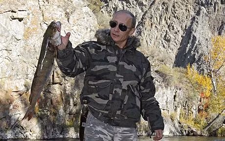 Wearing camouflaged fatigues for his hunting trip, Russian Prime Minister Vladimir Putin proudly holds up his big catch while fishing in the Ubsunur Hollow Biosphere Preserve