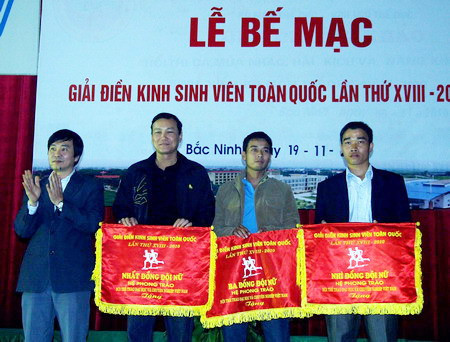 Ông Ngũ Duy Anh - Vụ trưởng Vụ công tác HSSV (Bộ GD&ĐT) trao cờ lưu niệm cho nhất, nhì, ba đồng đội nữ cho các VĐV