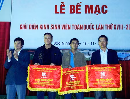 Ông Ngũ Duy Anh - Vụ trưởng Vụ công tác HSSV (Bộ GD&ĐT) trao cờ lưu niệm cho nhất, nhì, ba đồng đội nữ cho các VĐV