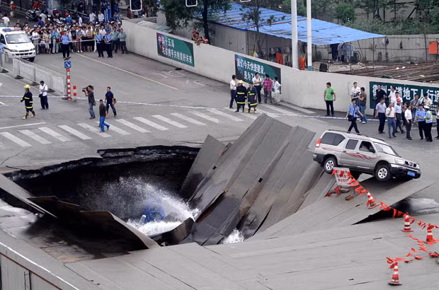 A road suddenly sank in Hefei, Anhui Province, China, in August 2009, causing one taxi and three motorbikes to fall into the hole