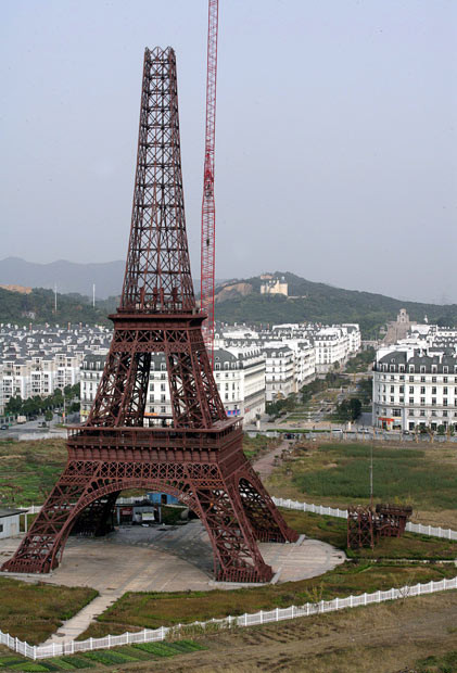 Một mô hình tháp Eiffel cao 108 mét đang được dựng lên ở Hàng Châu, Trung Quốc A crane is used to dismantle the 108-metre-tall replica of the Eiffel Tower in Hangzhou in east China’s Zhejiang province. The replica Eiffel tower, installed in 2007, is being relocated to give way to the construction of a subway station