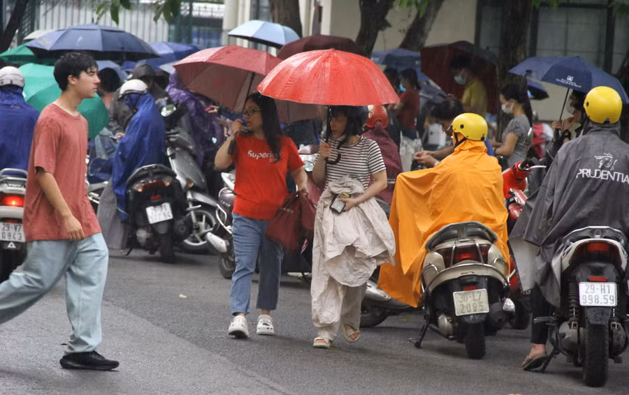 Phụ huynh và thí sinh đội mưa đến trường thi.
