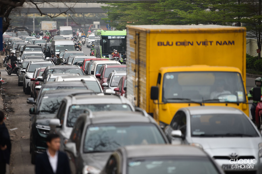 Việc hàng dài xe ô tô xếp hàng đợi đến lượt vào đăng kiểm lại tiếp diễn trên đường phố Hà Nội.