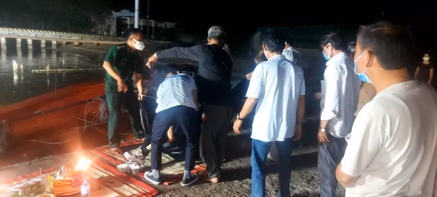 Lực lượng chức năng đưa thi thể nạn nhân vào bờ.