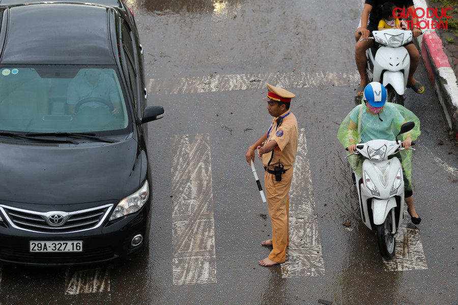 Những chiến sĩ CSGT đã bỏ cả giầy để đứng phân làn giữa trời mưa, ngập