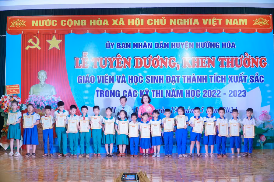 Ông Phan Hữu Huyện - Phó Giám đốc Sở GD&ĐT và bà Nguyễn Thị Thanh Nga - Trưởng Phòng GD&ĐT huyện Hướng Hóa khen thưởng các học sinh.