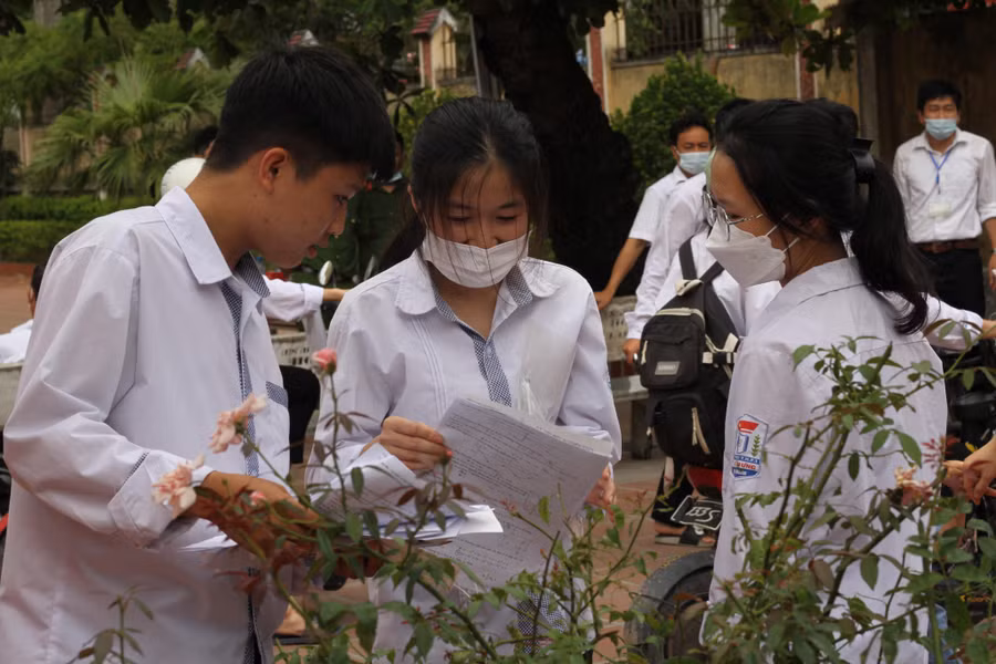 Một nhóm thí sinh soát lại kết quả môn thi trong tâm trạng hồ hởi.