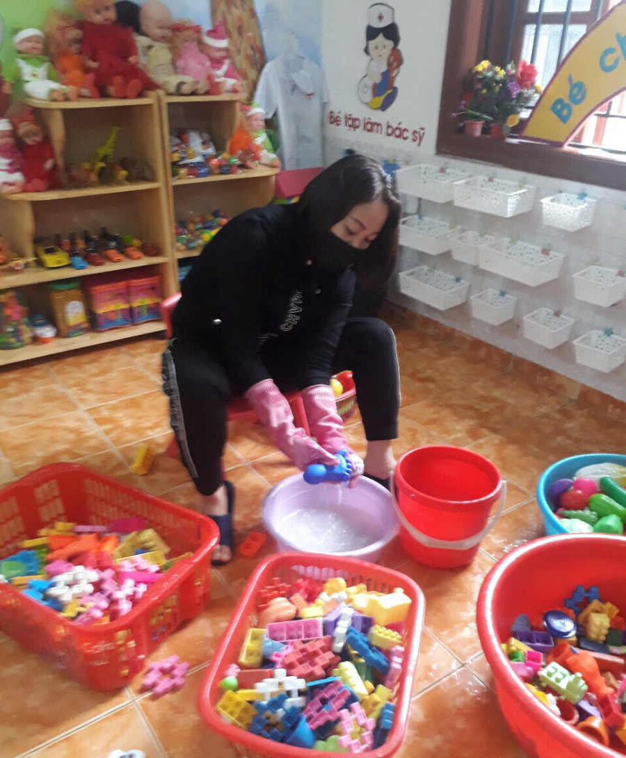 Cô giáo tẩy rửa các thiết bị dạy học