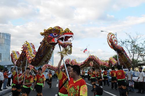People perform dragon dance to welcome the Chinese traditional lunar New Year in front of the biggest shopping mall of Philippines in Manila, Feb. 13, 2010. (X
