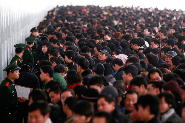 Khoảng 150 triệu người Trung Quốc chen chân về quê ăn Tết ảnh 3 Passengers queue to buy train tickets at a station in Shanghai