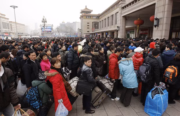Thousands of people queue outside a railway station in Beijing