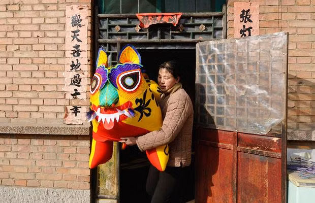 A farmer carries a toy made to resemble a tiger in Guotuo village, Licheng county, Shanxi province, China
